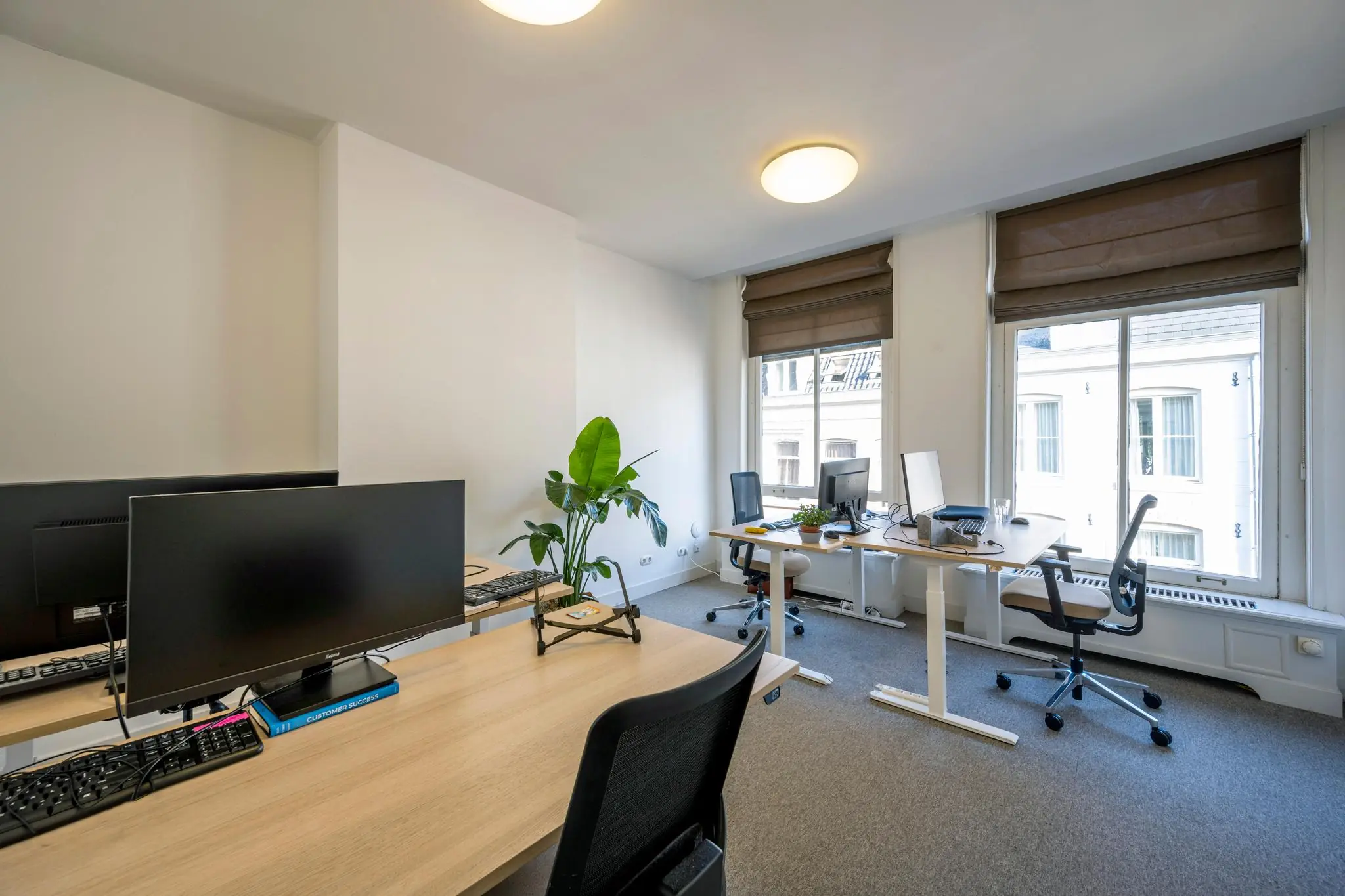 Modern ingericht kantoor met meerdere werkplekken, computers en grote ramen aan de Prof. Tulpstraat.